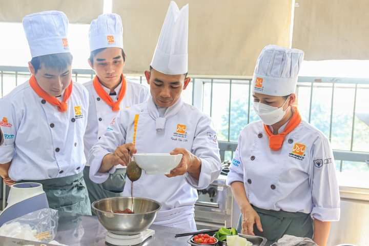 Đầu bếp Nguyễn Văn Tiến (ở giữa) - Một đầu bếp tài năng, một người thầy tận tụy, luôn truyền cảm hứng và ngọn lửa yêu nghề đến từng học viên của mình