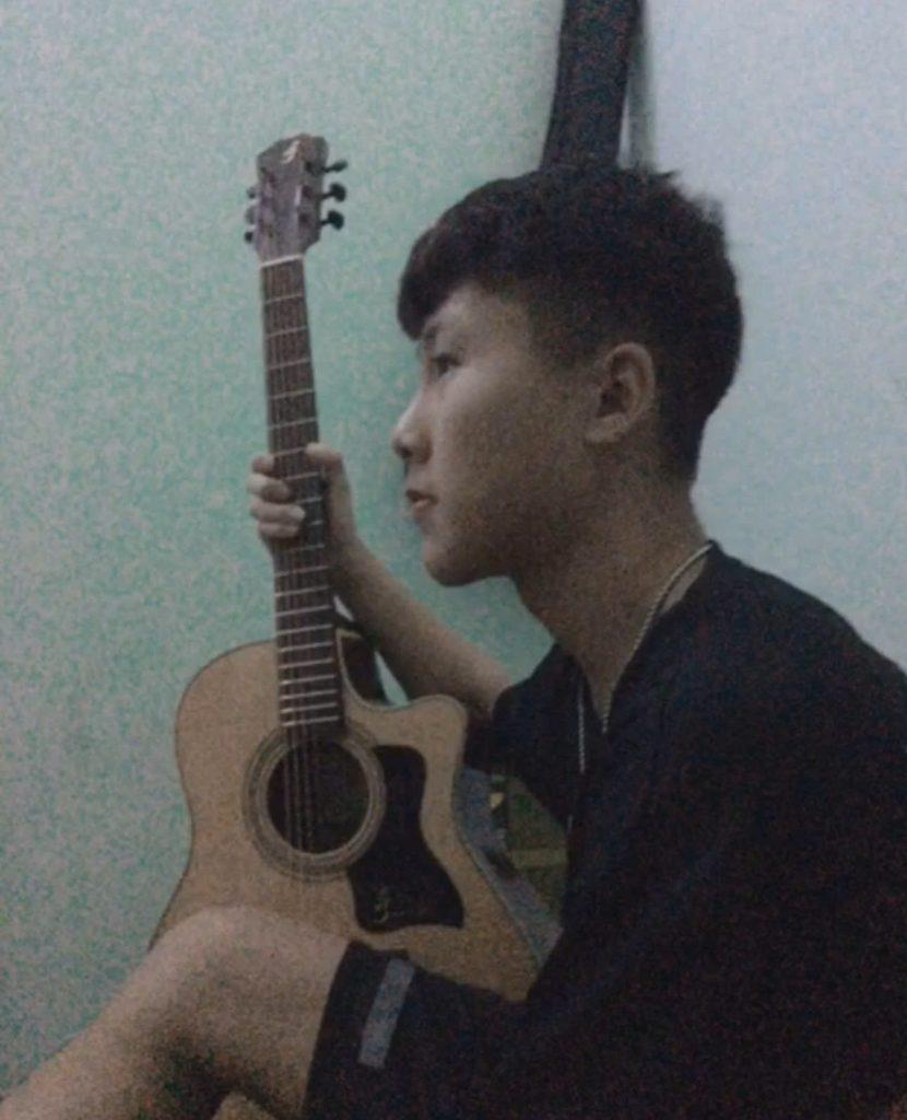 Nguyễn Việt Nhật bên cây đàn mượn tạm của người anh họ